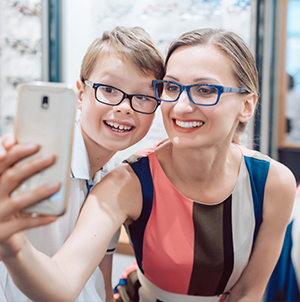 Mother and son smiling wearing glasses taking a selfie