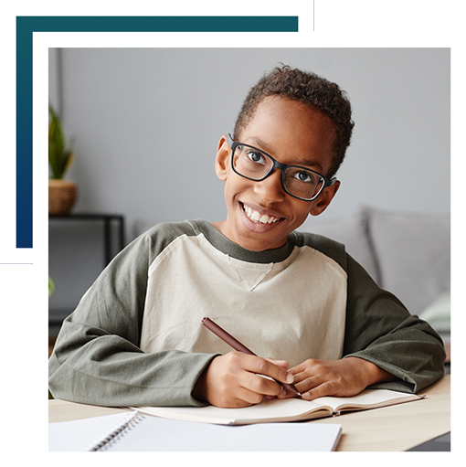 Boy wearing glasses smiling and studying